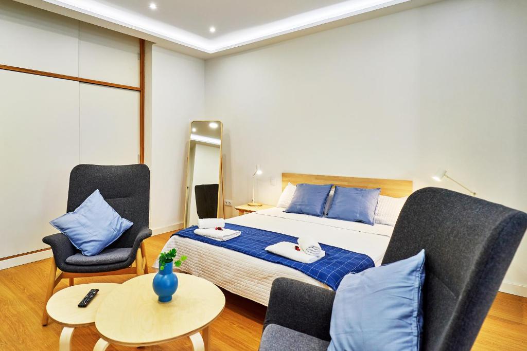 een slaapkamer met een bed, twee stoelen en een tafel bij VUT San Cristóbal LARANITASALAMANTINA in Salamanca