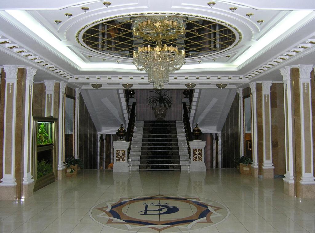 een grote lobby met een kroonluchter en een trap bij Dnipro Hotel in Tsjerkasi