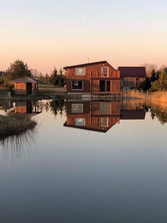 a house sitting on top of a body of water at Pas Garfildą in Vatušiai