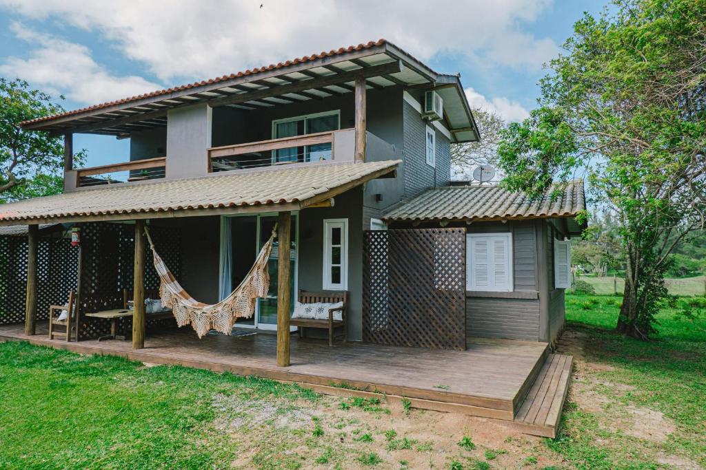 a house with a wooden deck in the yard at Pousada Natural Park in Imbituba