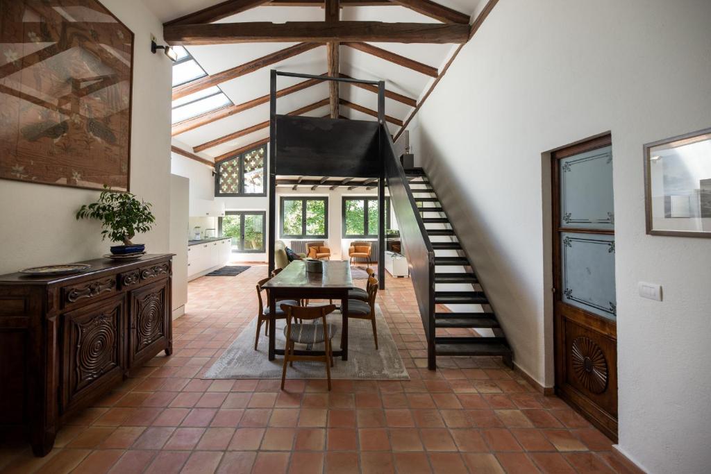 uma sala de jantar com uma mesa e uma escada numa casa em Casa Silvana em Alba