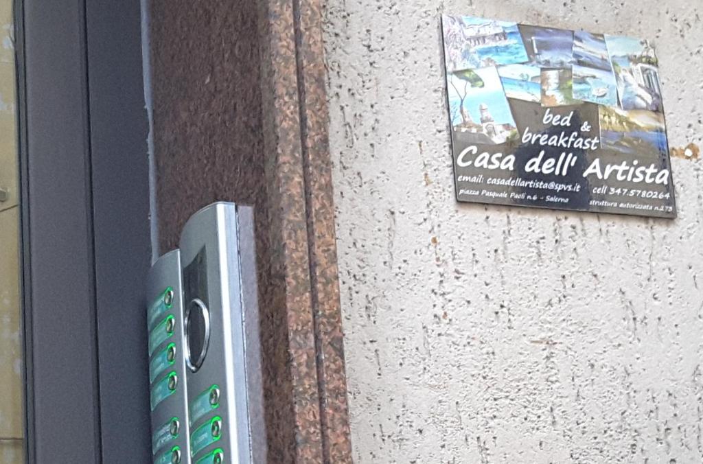 un telecomando su un muro con un libro di Casa dell'Artista a Salerno