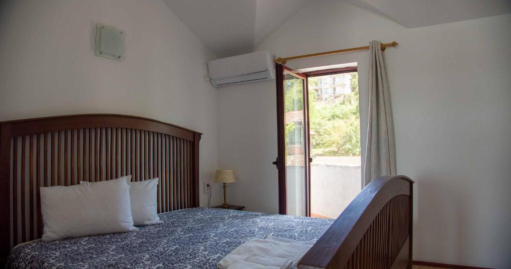 een slaapkamer met een bed en een glazen schuifdeur bij Хотел "Лодката" in Tutrakan