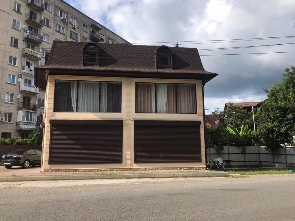 a house with a brown roof on a street at LUX in Pizunda