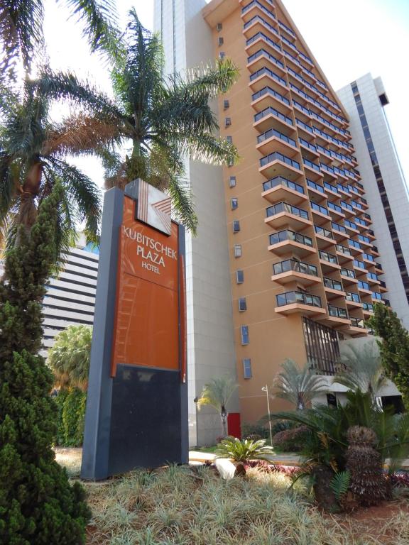 un edificio con un cartel frente a una palmera en JK Apart Hotel - Kubitschek Plaza en Brasilia