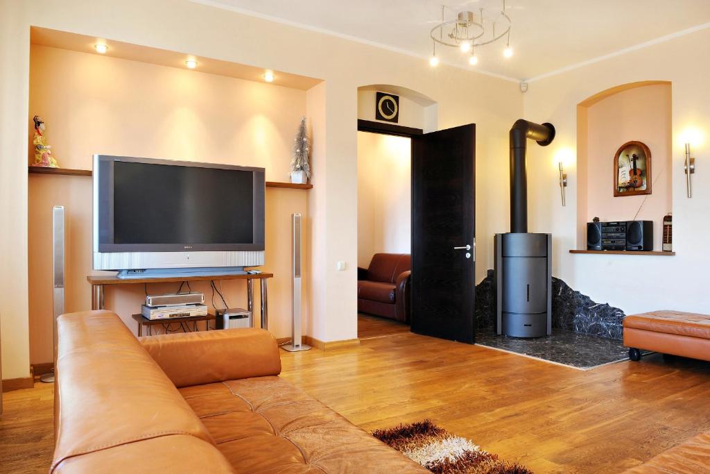 sala de estar con sofá y TV de pantalla plana en Raina Lux Apartment, en Riga