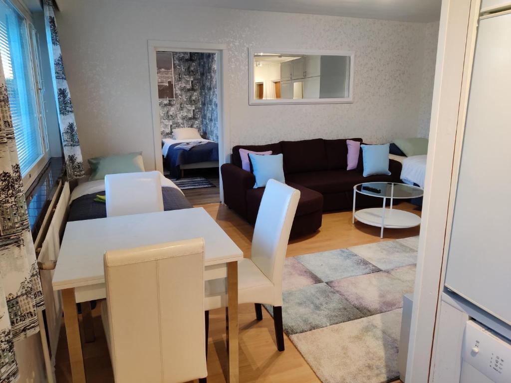 een woonkamer met een bank en een tafel bij M Apartments Vuorentaustantie in Tampere