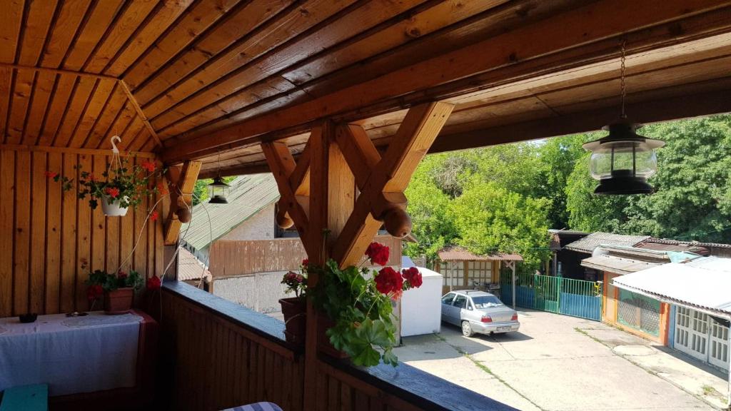 a balcony with a wooden roof with flowers on it at D&M in Neptun