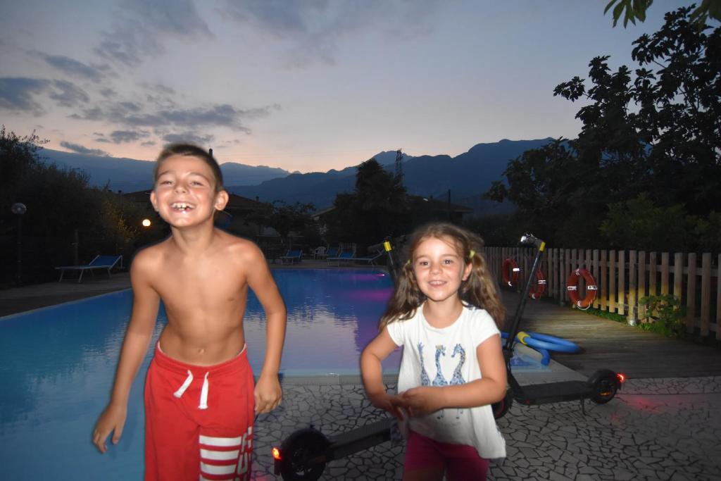 dos niños pequeños parados junto a una piscina en Agritur Michelotti Giancarlo, en Arco