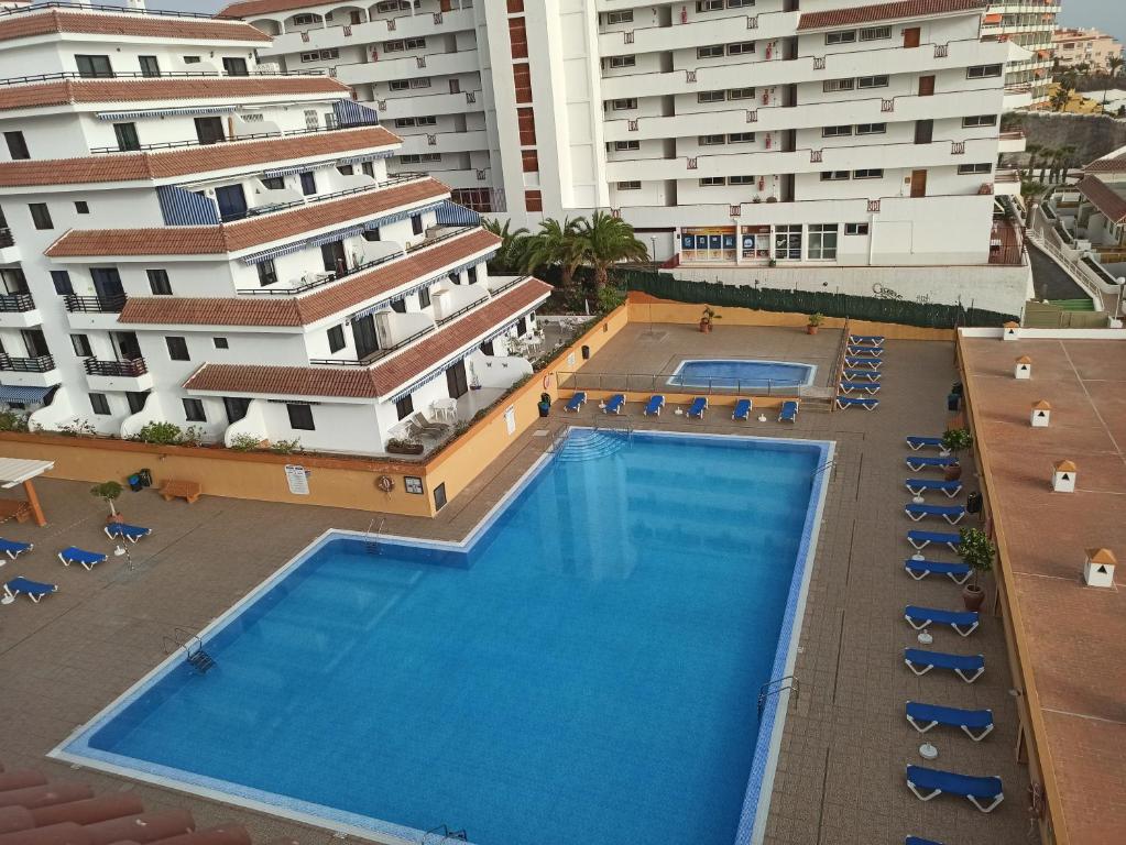 widok na basen przed budynkami w obiekcie Apartamento Playa La Arena w mieście Puerto de Santiago