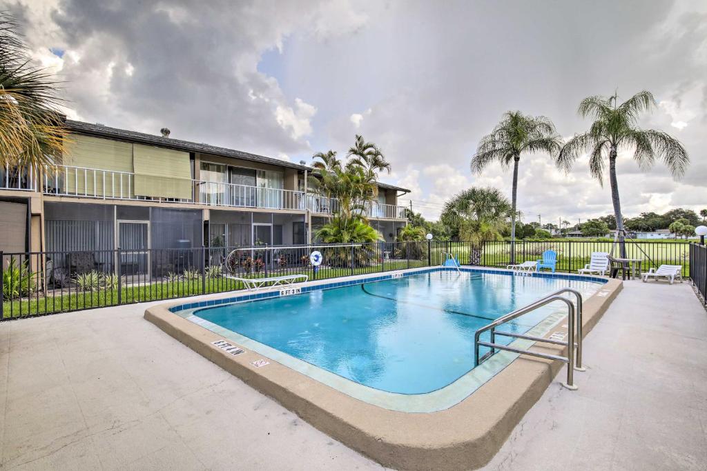 a swimming pool in front of a building with palm trees at Condo with Pool Access Less Than 4 Miles to Siesta Key Beach in Sarasota