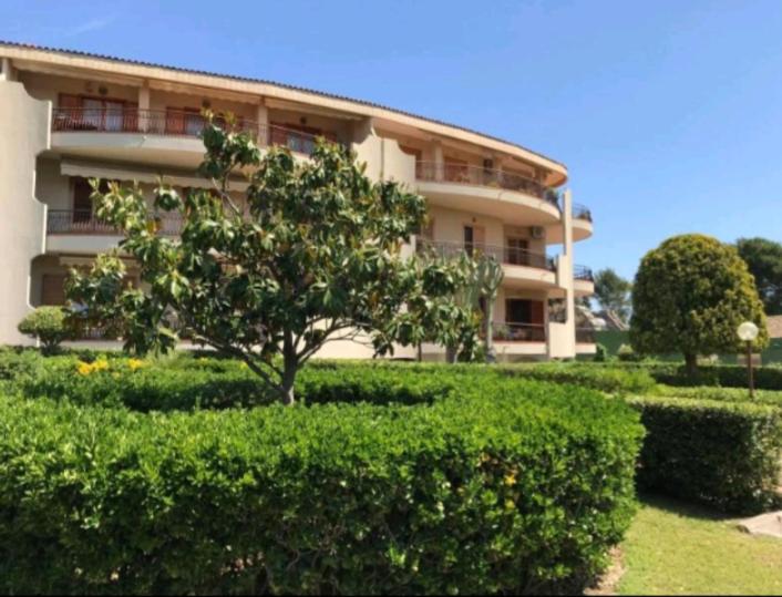 a building with a tree and bushes in front of it at Casa Adriana in Siracusa