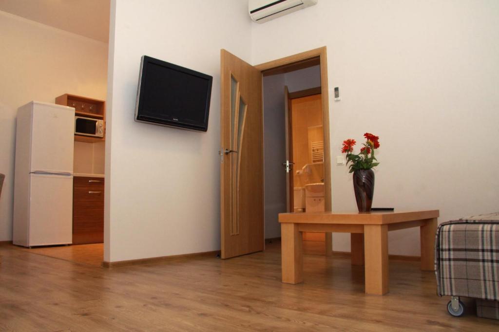 a living room with a vase of flowers on a table at Litrada Apartments in Šiauliai
