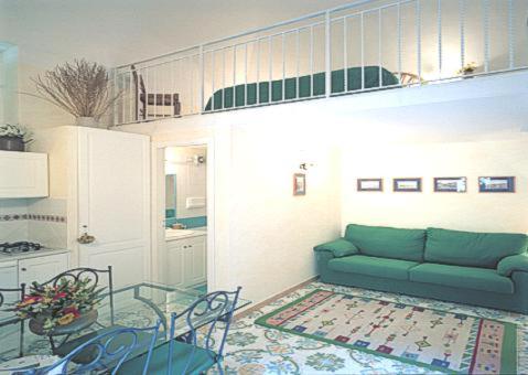 een woonkamer met een groene bank en een tafel bij La Dolce Meta in Meta