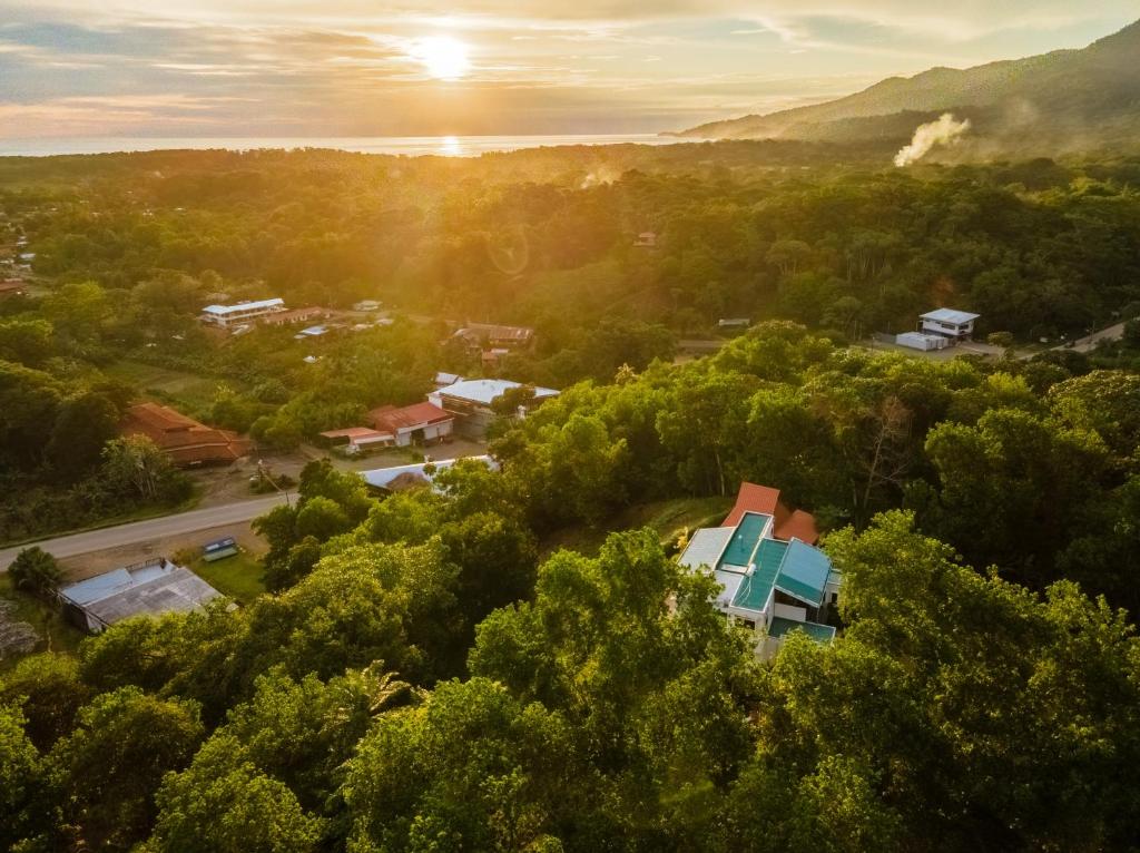 an aerial view of a town with trees and the sunset at Casa Unicornio Azul in Uvita