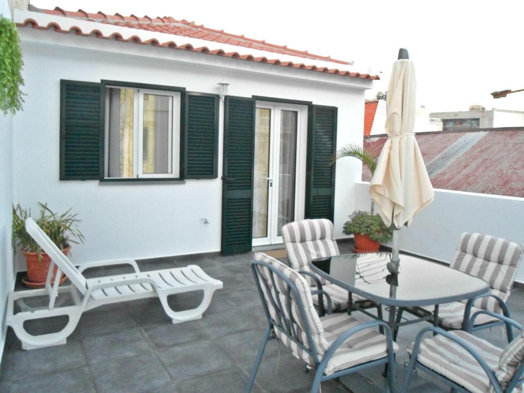 a patio with a table and chairs and a umbrella at Terrace Apartment in Funchal