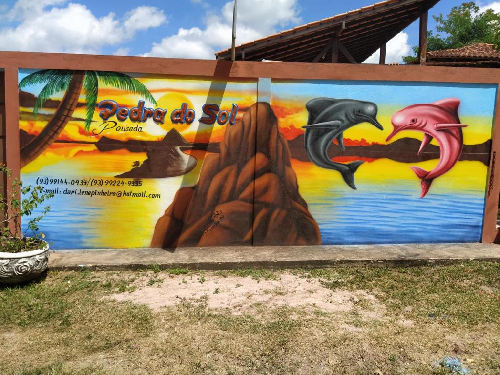 un muro con un murale di delfini di Pedra do Sol Pousada ad Alter do Chão