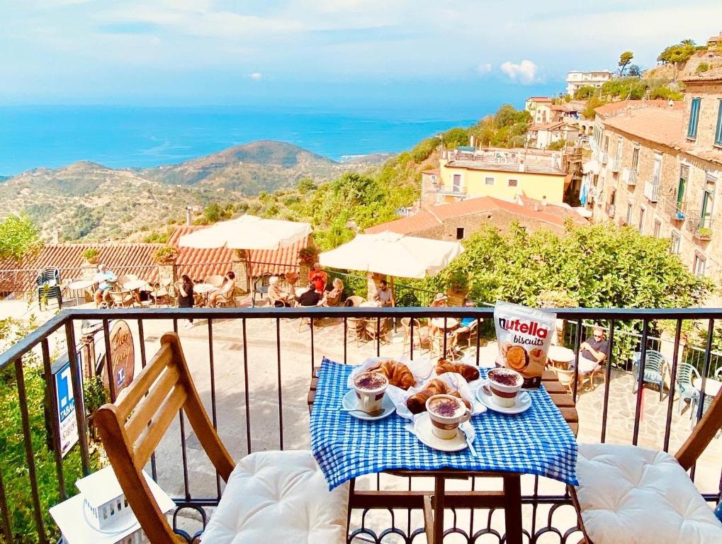 a table with cups of coffee and pastries on a balcony at Sdraiati Apartments - Bed & Breakfast - Pollica in Pollica
