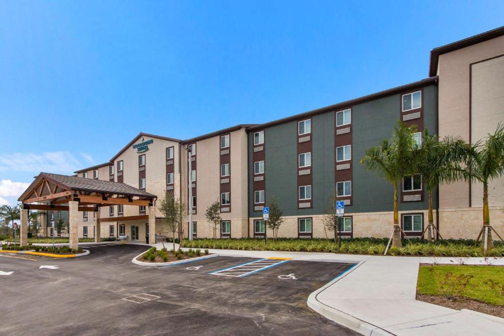 a large building with a parking lot in front of it at WoodSpring Suites Tamarac in Tamarac