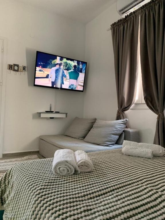 a bedroom with a bed and a tv on the wall at Dominik apartment in Patmos