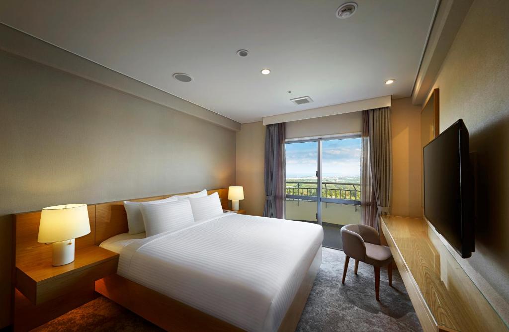 Un pat sau paturi într-o cameră la ANA Crowne Plaza Resort Okinawa Uruma Hills By IHG
