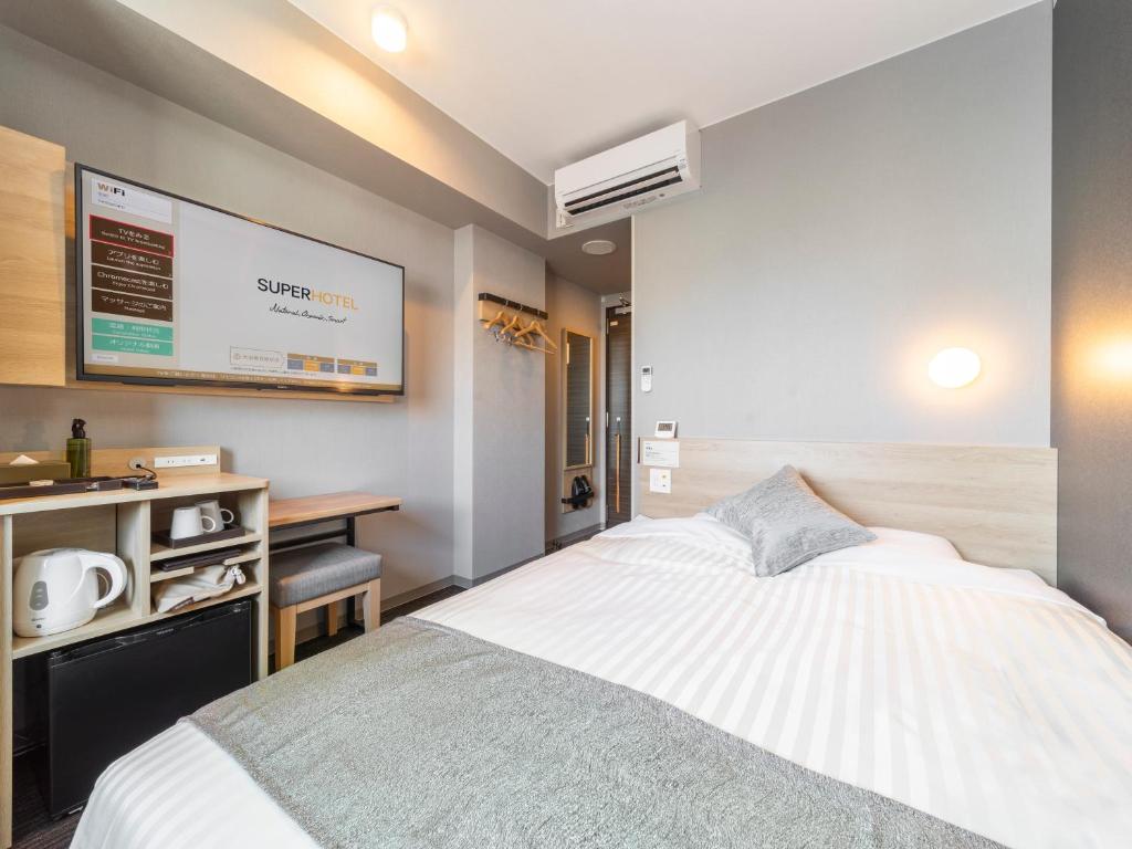 a bedroom with a bed and a flat screen tv at Super Hotel Premier Kanazawaeki Higashiguchi in Kanazawa