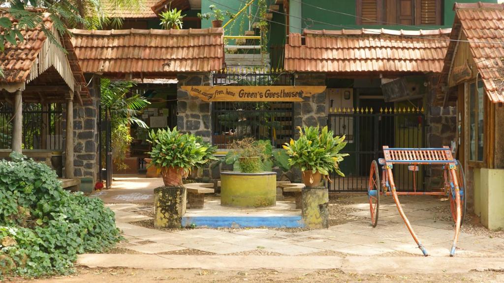 a store with potted plants in front of a building at Green's Guest House in Auroville