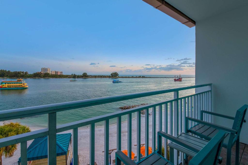 uma varanda com 2 cadeiras e vista para a água em Winter the Dolphin's Beach Club, Ascend Hotel Collection em Clearwater Beach