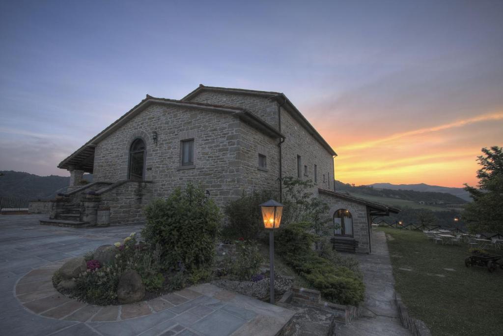 una vieja iglesia de piedra con una luz de la calle delante de ella en Agriturismo Acero Rosso, en Civitella di Romagna