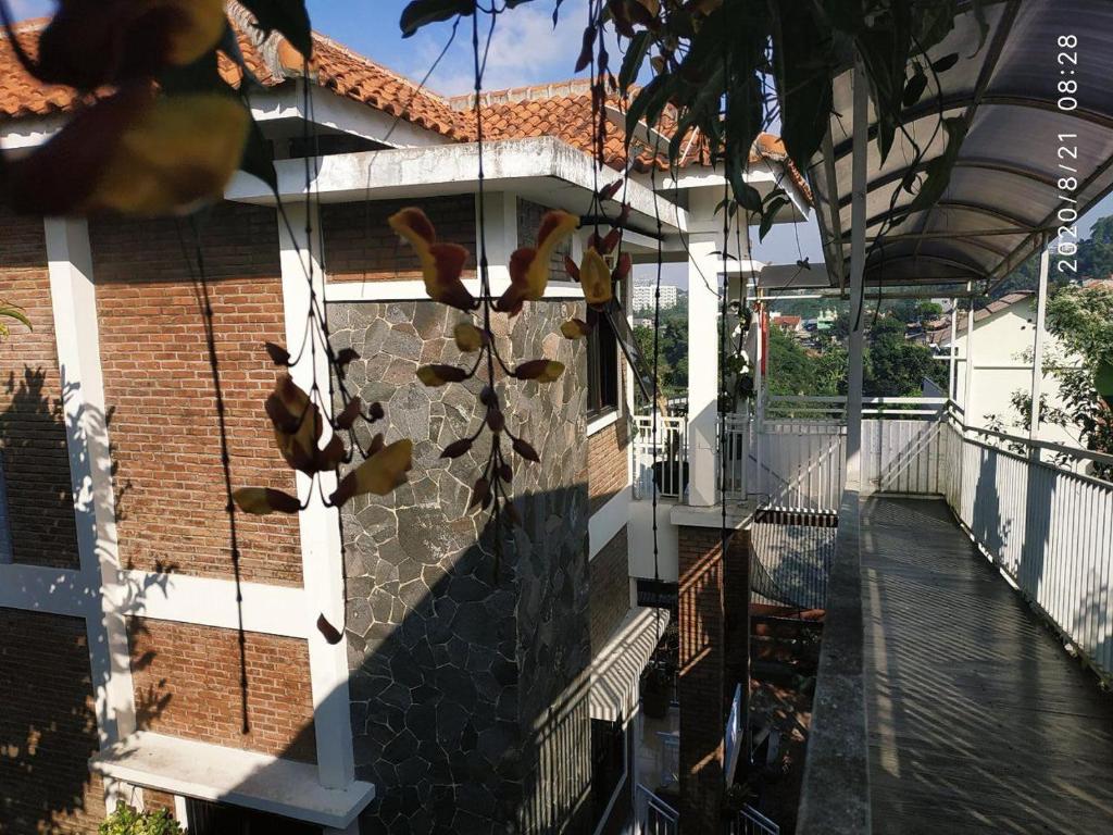 een balkon van een huis met een boom en een gebouw bij The Bridge Villa Punclut in Bandung