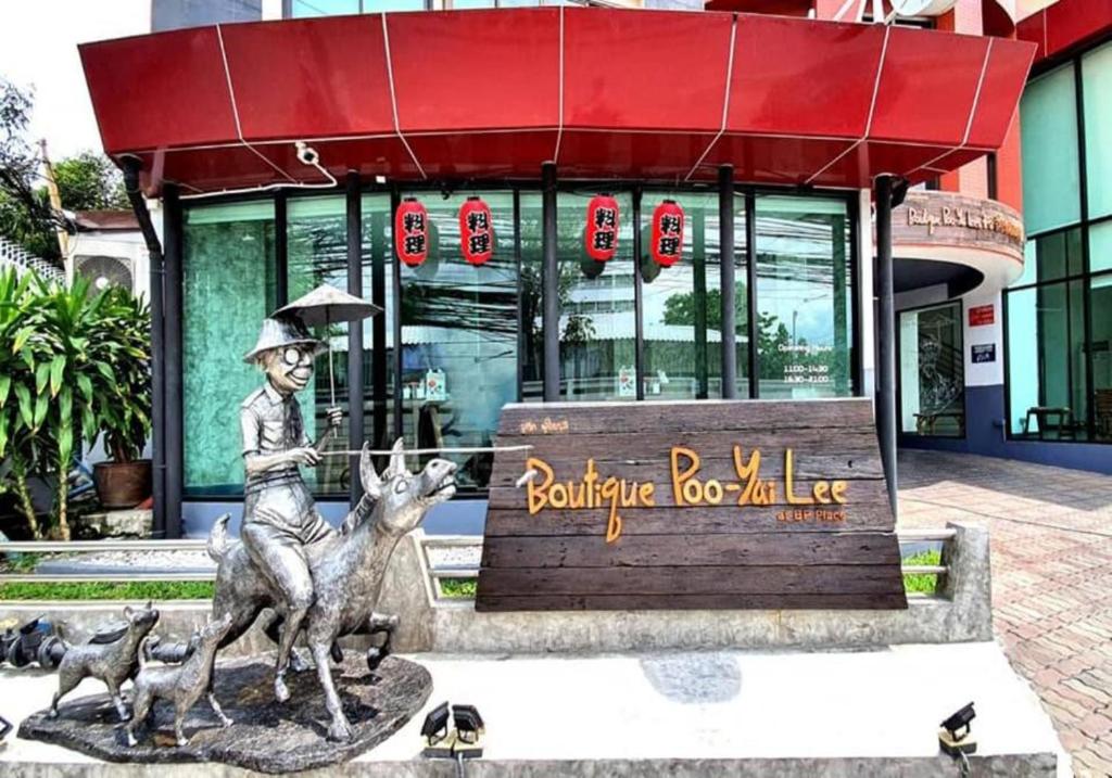 a statue of a boy riding deer in front of a building at Boutique Poo-Yai Lee in Bangkok