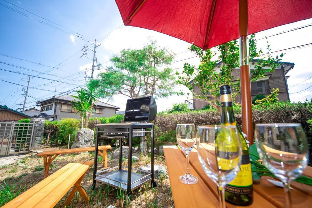 uma mesa de madeira com copos de vinho e um guarda-chuva em Yokkaichi Hazunaka Hotel em Yokkaichi