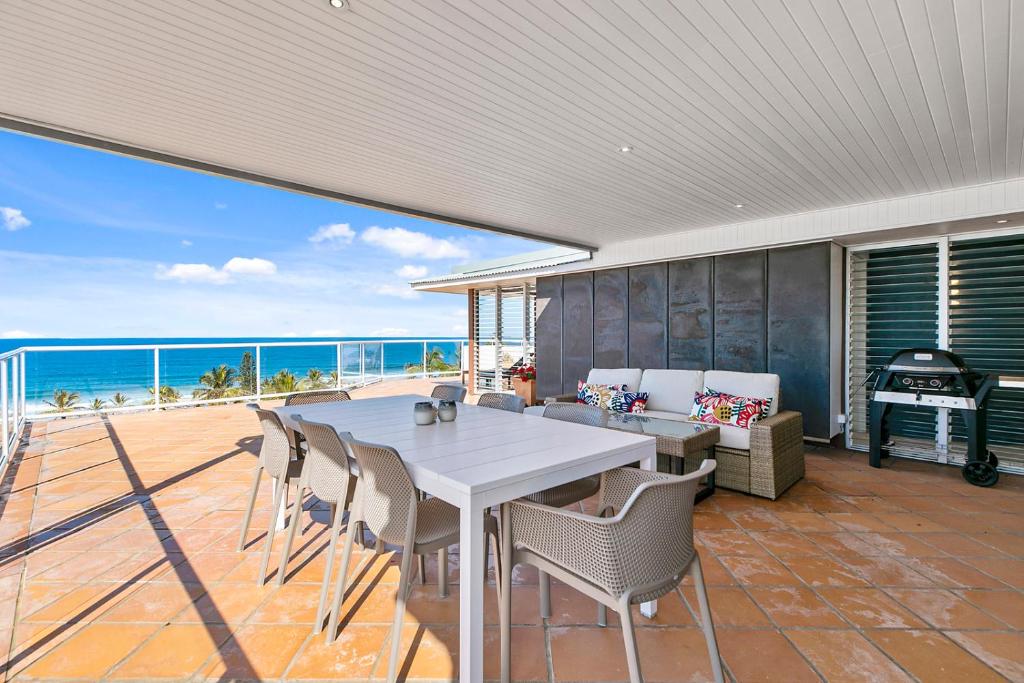 a dining room with a table and chairs and the ocean at Seascape in Sunshine Beach