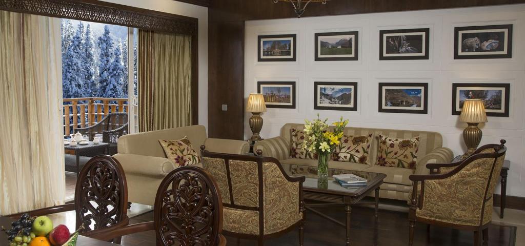 a living room with a couch and a table with chairs at The Khyber Himalayan Resort & Spa in Gulmarg