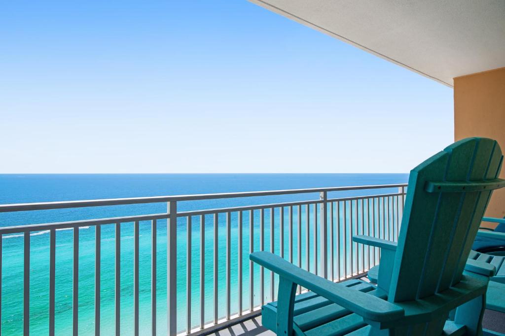 una sedia blu seduta su un balcone con vista sull'oceano di Splash Resort 2002W a Panama City Beach