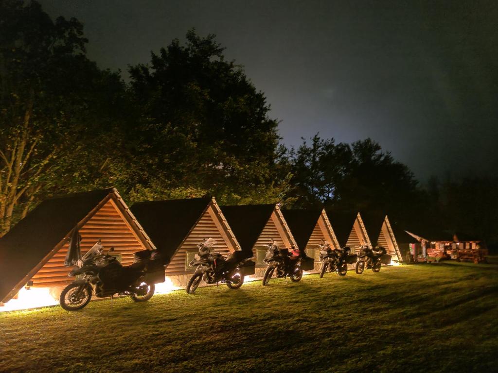 eine Gruppe von Motorrädern, die vor einer Reihe von Zelten geparkt werden in der Unterkunft Camping Drina in Foča
