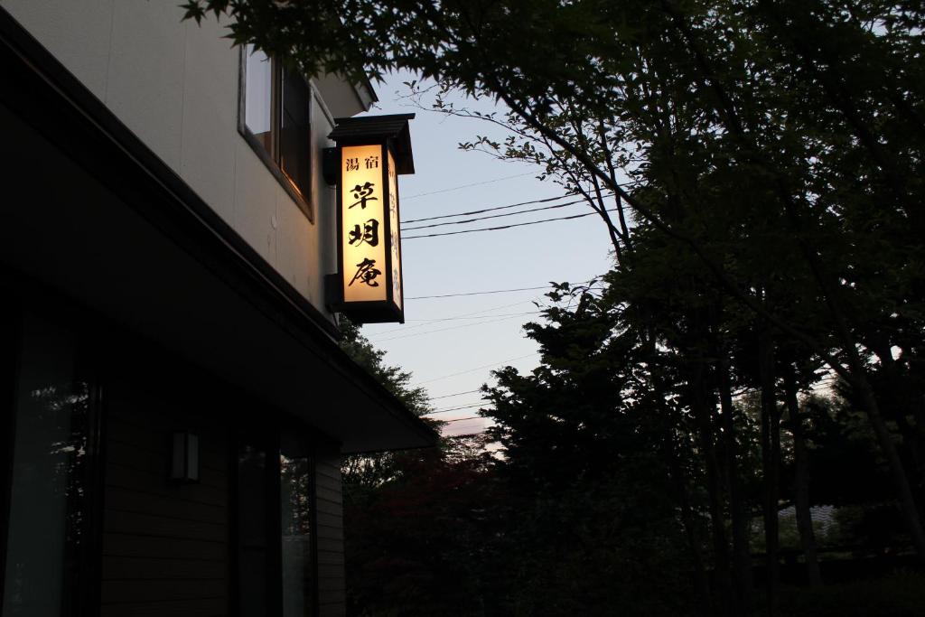 una señal colgando de un lado de un edificio en Soumeian, en Kusatsu