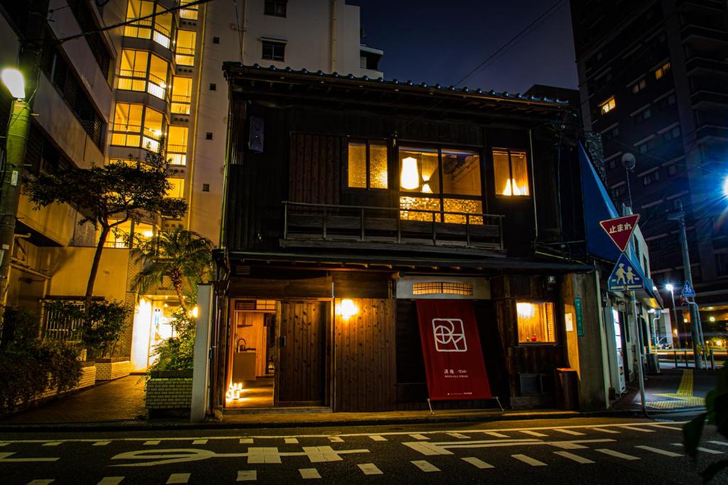 a building on the corner of a street at night at MACHIYA-VILLA SEIAN in Fukuoka