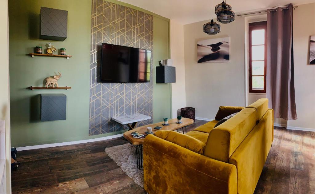 sala de estar con sofá amarillo y TV en Sublime vue, standing, spacieux, atypique en Muret