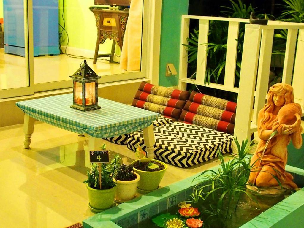 sala de estar con mesa y algunas plantas en Baan Saithong en Ko Larn