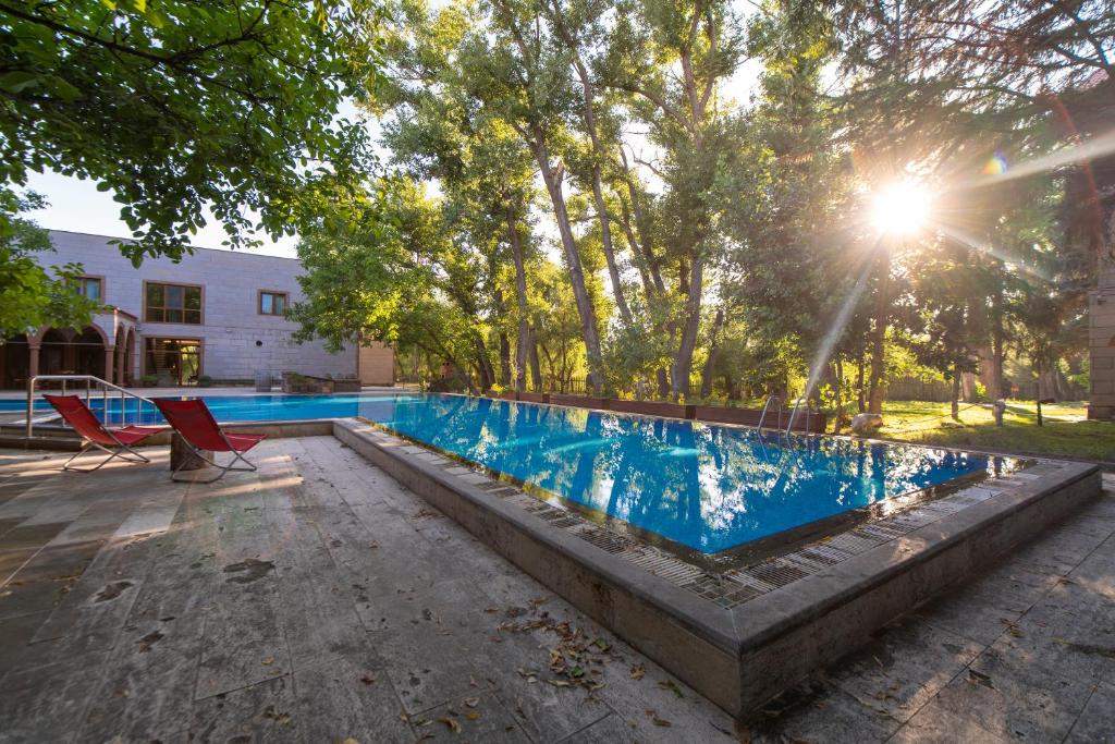 einen Pool mit einem Stuhl neben einem Gebäude in der Unterkunft SUNOLUS VINEYARDHOUSe in Kayseri