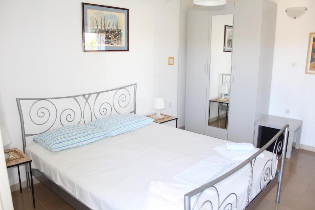 een slaapkamer met een groot wit bed in een kamer bij Apartments DeMori in Primošten