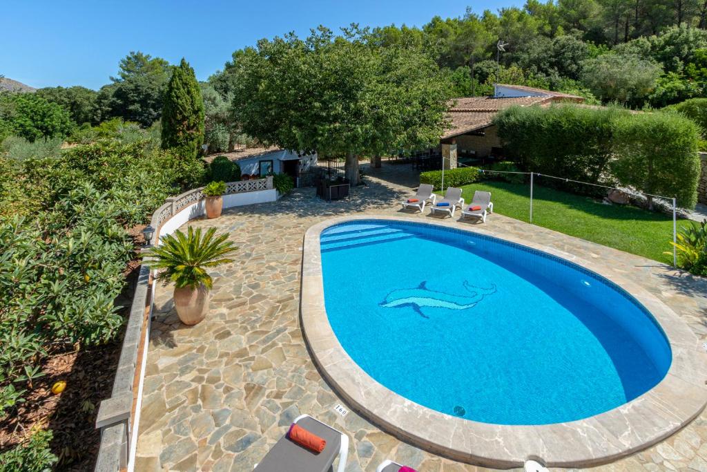 una piscina en un patio con un delfín pintado en Villa Can Parades By homevillas360, en Pollensa