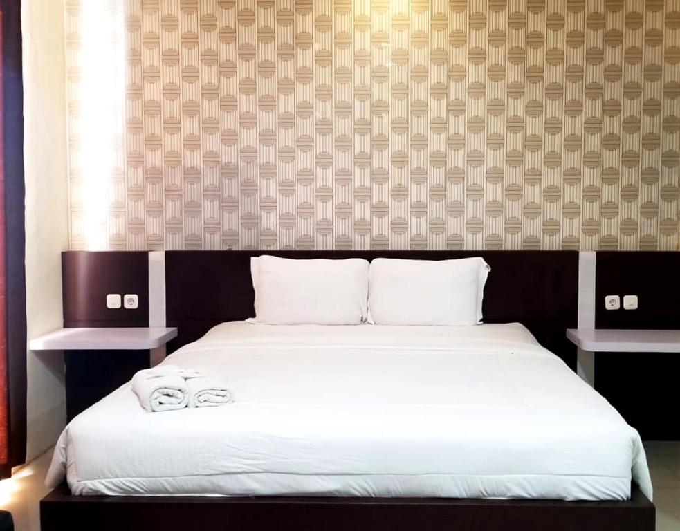 Postel nebo postele na pokoji v ubytování Jember City Hotel