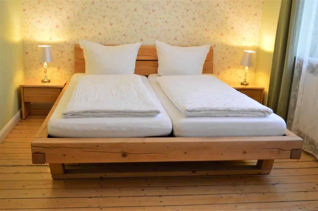 Duas camas individuais sentadas numa cama de madeira num quarto em Altstadtpension Hameln em Hameln