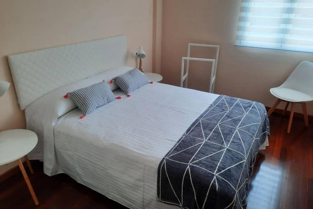 ein Schlafzimmer mit einem großen Bett mit zwei Tischen und einer Leiter in der Unterkunft Soraya en el fin de la tierra B in Kap Finisterre