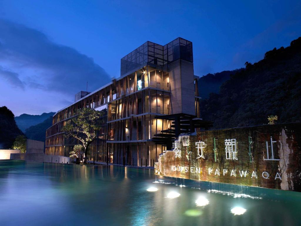 a building next to a body of water at night at Onsen Papawaqa in Taian