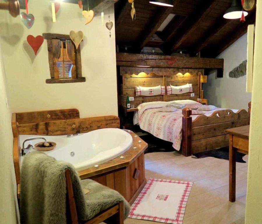 um quarto com uma cama, uma banheira e um lavatório em Romantica suite con vasca idromassaggio em Aosta