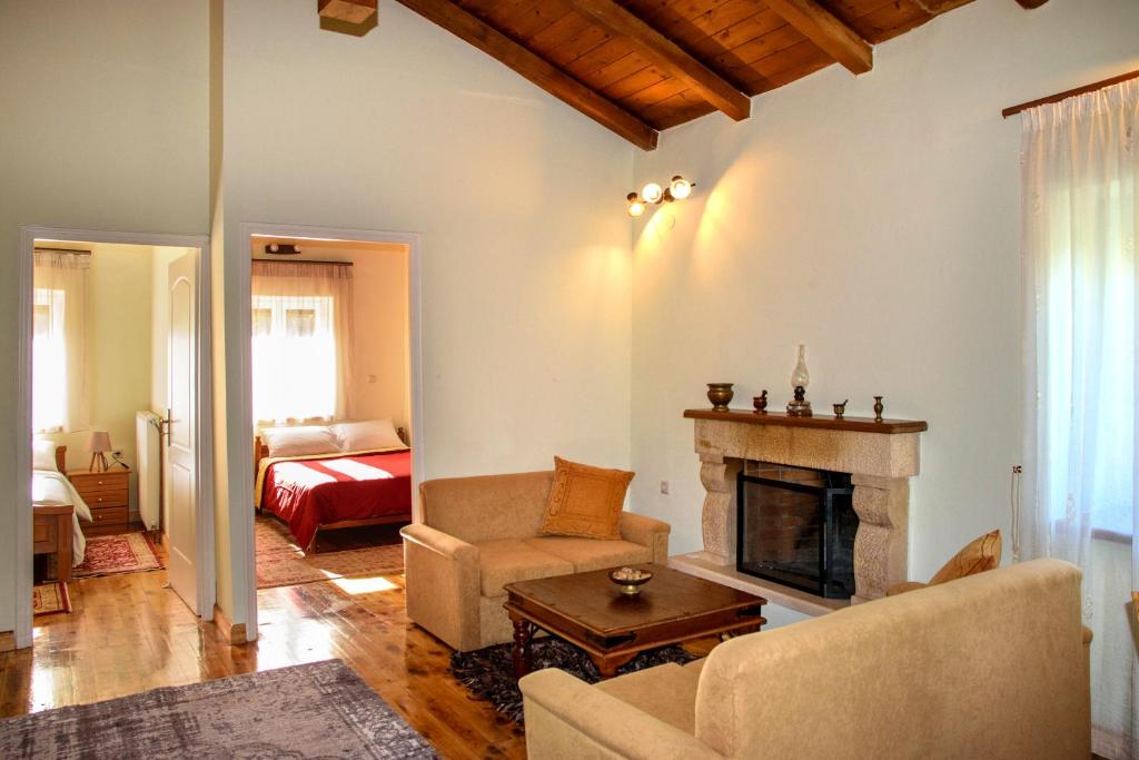 a living room with a fireplace and a bed at Dual house in Methydrio in Vytina