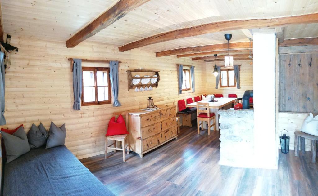 uma sala de estar com paredes de madeira e piso de madeira em Ampferkaralm Hütte em Forstau